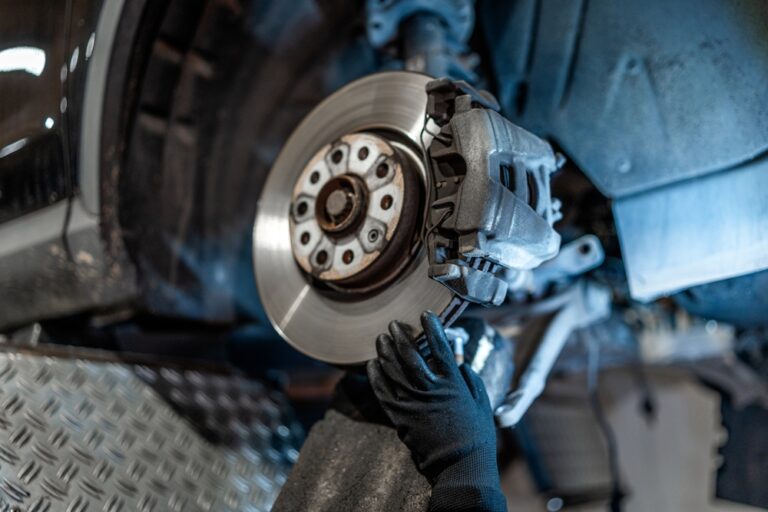 Mechanik kontroluje brzdový kotúč a doštičky pri servisnej prehliadke vozidla